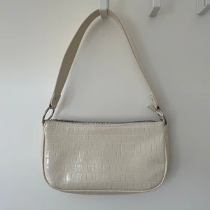 Beige axelväska från H&M  - Snygg beige axelväska med dragkedja. Väskan är från H&M divided, perfekt till sommaren. Mycket bra skick, endast använd fåtal gånger. 💕