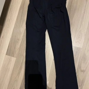 Svarta byxor - Snygga mörkblå byxor yogapants med låg midja och bootcut-stil. Perfekta för en stilren look. Tillverkade i ett mjukt och bekvämt material som ger en skön passform. passar inte längre och där med säljer jag dem. 
