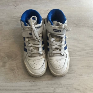 Vita och blå sneakers från Adidas - Adidas forum High, sparsamt använda. Nypris ca 900.