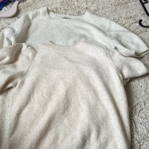 Beige stickade tröjor Vero Moda & H&M - Två mjuka stickade tröjor i beige från Vero Moda och H&M. Båda har rund hals och ribbade muddar. Vero Moda-tröjan har puffärm för extra stilpoäng, medan H&M-tröjan har klassisk rak passform. Du får båda på köpet 