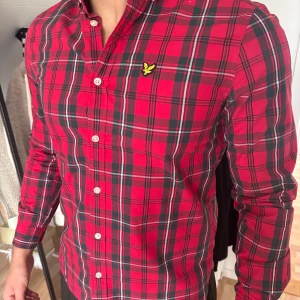 Rutig röd skjorta från Lyle & Scott - Snygg röd rutig skjorta från Lyle & Scott med klassisk button-down krage. Knappt använd, kommer i ett mycket bra skick.  