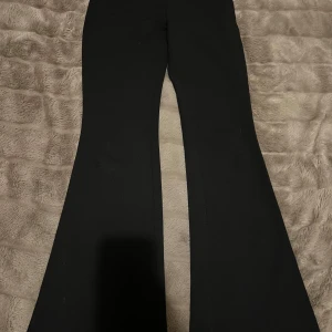 Svarta bootcut leggings - Byxorna har en snygg utsvängd passform och är tillverkade i ett stretchigt material som sitter bekvämt. 