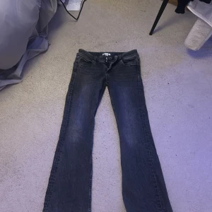 Mörkgrå bootcut jeans  - Snygga mörkgrå jeans från Gina Tricot i storlek 152. Modellen har bootcut-ben och klassisk femficksdesign med knappar framtill och fickor med lock bak. Jeansen är i ett stretchigt denimtyg som sitter skönt och ger en cool look.