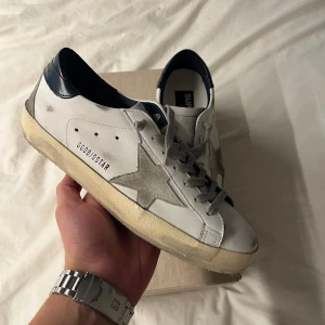 Golden Goose skor - Hej, säljer dessa helt nya golden goose superstars med box, alla tillbehör! Och äkthetscertifikat! | Storlek: 40 | Passar: 41 | Skick: 10/10 helt nya | Kommer med box | Tveka inte att höra av dig vid frågor eller funderingar😊