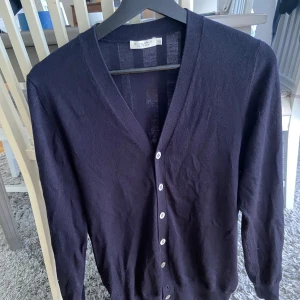 Suitsupply - Riktigt skön cardigan från Suitsupply i 100% merinoull. Storlek XS men väldigt elastisk i materialet så kan även passa S. Knappen näst längst ner saknas, men det är inget man tänker på eller ser. I övrigt mycket fint skick. Nypris runt ~2000kr