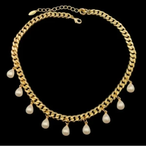 Guldpläterat halsband med pärldroppar - Chunky guldfärgat halsband med kedja och hängande vita pärldroppar runt om. Halsbandet har justerbar längd och ger en cool och trendig vibe med sina glänsande detaljer. Perfekt för att lyfta vilken outfit som helst med en touch av lyx.