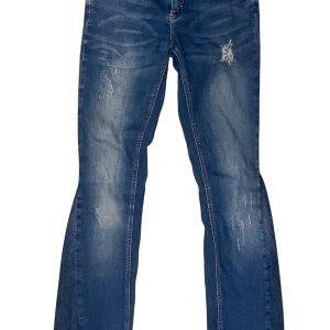 Lågmidjade Bootcut jeans med snygga detaljer - Jättesnygga lågmidjade Bootcut jeans med snygga ”slitna” detaljer i blå färg. Har själv sytt om från ett par skinny jeans! Storlek XS enligt måtten men passar troligtvis även S eftersom det är stretchiga! Längden passar nog 155-165 cm ( se mått nedan )  Defekter: lite trådar lösa vid fickorna Midja: 32cm bred Innerbenslängd: 74cm Ytterbenslängd:94 cm Front Rise: ( midja till grenen fram) 17 Cm Back Rise: ( midja till grenen bak) 30 cm Skriv gärna om frågor osv och skicka prisförslag!!!⭐️