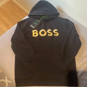 Svart hoodie från BOSS med guldtext - Skriv innan så jag vet att ni ska beställa o så vidare 