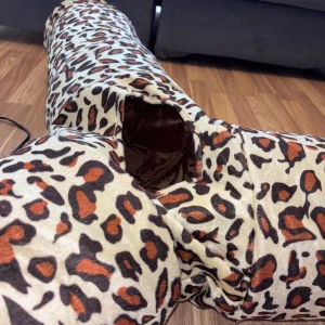 Katt tunnel använd 2 gånger  - Rolig och stimulerande kattunnel i Y-form. Perfekt för katter som älskar att leka och utforska. Tunneln är tillverkad i ett mjukt material med leopardmönster och har en rymlig insida. Använd 2 gånger kan mötas upp eller Sicka det