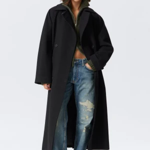 Svart lång kappa med bälte - Säljer en svart, lång och oversized kappa med bälte i midjan och dubbelknäppning, tillverkad i ullblandning. Helt slutsåld i alla storlekar!!!! Helt ny med alla lappar kvar💗