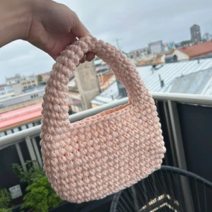 Virkad väska - Hemmavirkad ljusrosa väska i 100% t-shirtgarn i överskott från textilindustrin. Väskan är 23cm bred, 14cm hög och 26cm hög inklusive handtag. Aldrig använd