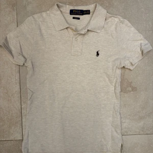 Beige pikétröja från Polo Ralph Lauren - Klassisk beige/grå pikétröja från Polo Ralph Lauren. 