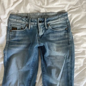 G-Star ljusblå jeans med slits - Snygga ljusblå jeans från G-Star Originals med klassisk femficksdesign, råa detaljer och slitsar nertill på benen. 