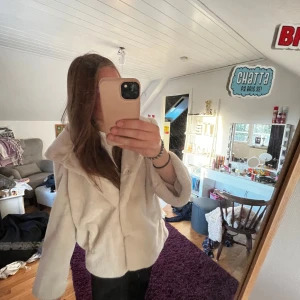 Beige/vit pälsjacka från Bubbleroom - Säljer en supermjuk och fluffig beige pälsjacka från Bubbleroom by Molly Rustas. Jackan har en oversized passform, bred krage och långa ärmar. Perfekt för dig som vill ha en mysig och trendig look under kyliga dagar.