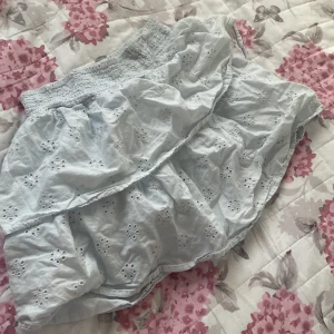 Ljusblå volangshorts från Gina Tricot - Supersöta ljusblå shorts från Gina Tricot med broderade hål mönster. Andvändts men e i bra skick 