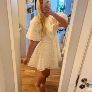 Klänning - Så vacker och fin klänning med fina detaljer och blomliknande mönster från hm! Aldrig använd och prislappen kvar. Fin snörning i ryggen man knyter i rosetter🤍💕💕🤍🌼🌷perfekt för student, konfirmation eller annat festligt tillfälle!