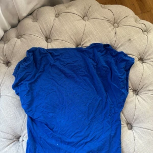 Kornblå enkel topp i bomull - En basic kornblå topp med korta ärmar och rund hals. Tillverkad i mjuk bomull, perfekt för en avslappnad och stilren look. Passar dig som gillar färg och enkelhet i garderoben.