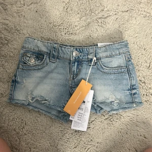 Ljusblå embroidery jeansshorts Gina Tricot !NYA! - Helt nya! Snygga ljusblå jeansshorts från Gina Tricot med låg midja, slitna detaljer och broderade bakfickor med paljetter. Rå kant nertill och klassisk femficksmodell. Perfekta för sommaren och riktigt trendiga.