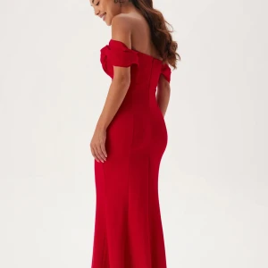 Röd offshoulder långklänning - Snygg röd långklänning med offshoulder och draperad överdel. Klänningen har figurnära passform och är tillverkad i ett slätt material som ger en elegant siluett. Perfekt för bal eller festliga tillfällen. Inga bilder när jag testade den men den ser exakt ut som på bilden! Aldrig använt!