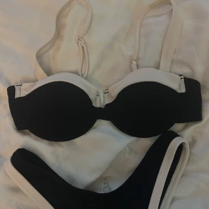 Svart och vit/beige bikini med bygel - Snygg bikini i svart med vita/beiga kanter. Storlek M på överdelen och S på underdelen men passar mig som har xs/s. Aldrig använd 