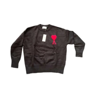 Ami Paris tröja  - Svart stickad tröja från Ami Paris med rund hals och ribbade muddar. På bröstet finns ett stort rött hjärta med bokstaven A, vilket ger en unik och trendig look. Perfekt för dig som gillar stilrena plagg med en twist. Skriv för mer bilder ! Inköpt på Plick !