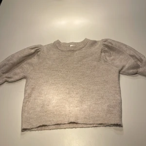 Beige stickad tröja från Gina Tricot - Supermjuk beige stickad tröja från Gina Tricot med puffiga långärmar och ribbade muddar. Perfekt för lager-på-lager och har en klassisk rund halsringning. Enkel att matcha med både jeans och kjol. Skriv om ni har ett annat prisförslag 