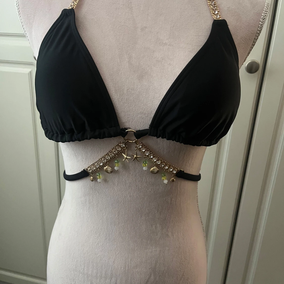 Svart bikini med gulddetaljer och pärlor