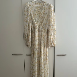 Lång blommig klänning med v-ringning - Superfin långklänning i ljus färg med gult blommönster och v-ringning🫶🏻