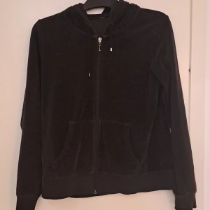 Svart velourhoodie från Cubus - Mjuk svart hoodie i velour från Cubus med dragkedja framtill, huva med snörning och två stora fickor. Perfekt för chill dagar eller när du vill ha en skön och stilren look. Långärmad och loose fit för extra komfort. Jag har själv köpt den på secondhand men har aldrig använt den
