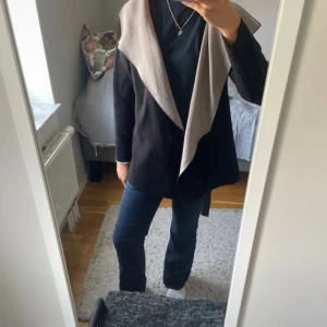 Svart och beige cardigan jacka från Zara - Snygg svart och beige cardigan jacka från Zara med öppen front och långärmad design. Jackan har en avslappnad passform och är tillverkad i mjukt stickat material, perfekt för lager-på-lager. Stilsäker och enkel att matcha till olika outfits. Storlek 11-12 men passar mig som har xxs-xs
