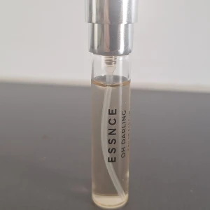 ESSNCE Oh Darling parfym ca 6,5 ml - En stilren och smidig parfym från ESSNCE med namnet Oh Darling. Flaskan är genomskinlig med silvrig spraykork och svart text. Perfekt storlek för att ta med i väskan. Doften är en eau de parfum och flaskan är gjord av glas.(8 ml ny, ni ser mängd kvar)