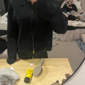 Svart zip-up cardigan jacka - Säljer en svart cardigan jacka med dragkedja framtill och två stora fickor på bröstet. Jackan har en enkel, clean look och är långärmad med rak passform. Perfekt för dig som gillar stilrena och minimalistiska plagg.