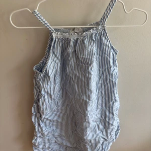 Randig sommarklänning från H&M - Söt kortklänning från H&M med smala axelband och blåvita ränder. Tillverkad i mjuk bomull, perfekt för varma dagar. Lätt och luftig modell med avslappnad passform och elastisk halsringning.