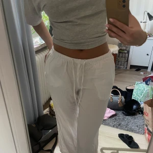 Vita lågmidjade linnebyxor från Gina Tricot - Säljer ett par fräscha lågmidjade vita linnebyxor från Gina Tricot. Byxorna har dragsko i midjan för skön passform och är raka i modellen. Har även framfickor på sidorna. Perfekta för varma dagar och chill vibes. Lätta och luftiga med relaxed fit.