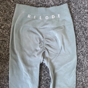 Grå gröna leggings från Relode - Snygga grå gröna  leggings från Relode med hög midja och scrunch-detalj bak. De är stretchiga och sitter tight, perfekta för träning eller chill. Materialet är mjukt och följsamt, och midjan är bred och ribbad för extra komfort.