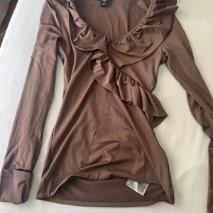 Brun volangtop från new yorker  - Supersnygg brun långärmad topp från new yorker med volang. Köpte förra året men har endast använts en gång så den är som ny!🩷