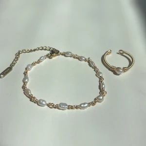 Smyckesset - Setet innehåller: ✓ Ett handgjort armband ✓ En justerbar ring  Armband: Längd: 16,5 cm + 6,5 cm förlängningskedja Material: Rostfritt stål, äkta sötvattenspärlor  Ring: Justerbar storlek Material: Rostfritt stål