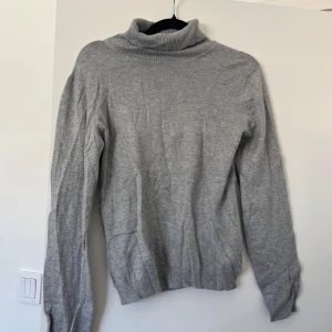 Grå polotröja i mjuk bomull - En stilren grå polotröja med lång ärm och ribbad krage. 