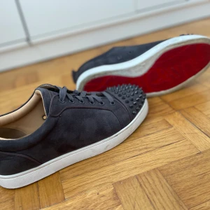 Grå loubs med spikar - Ett par gråa loubs med spikar i  storlek 43. Väldigt bra skick. Mockan är perfekt det ändå som visar på användning är sulan men det går lätt att få bort. Priset kan variera vid snabb affär. Box och dustbag ingår i köpet.