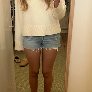 Levi's ljusblå jeansshorts 🌸 - Säljer ett par klassiska ljusblå jeansshorts från Levi's med fransade kanter. Shortsen har medelhög midja och en avslappnad passform, perfekta för sommaren. Ikonisk Levi's-lapp bak och röd etikett på fickan. Supersnygga! 🌸