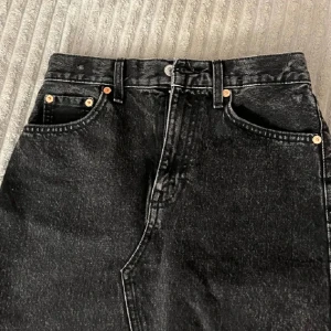 Svart jeanskjol från MNG - Snygg svart jeanskjol från MNG med knappstängning fram. Säljer då den inte sitter bra på mig! Fråga gärna om ni vill ha fler bilder💕Använt max 3 gånger!