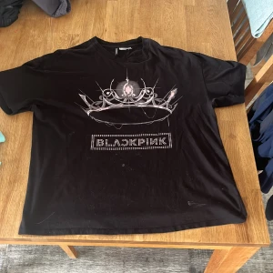 Svart BLACKPINK t-shirt Divided H&M - Svart T-shirt, i storlek S men känns som större storlek. Plagget har vissa fläckar, men ska tvätta och om du ha plagget kan jag skriva om fläckarna går bort eller inte:). Tröjan är från h&m och har tecken på användning.