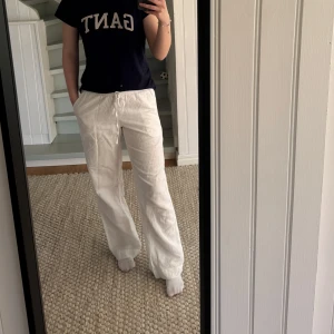 Vita linnebyxor från Neo Noir - Snygga vita linnebyxor från Neo Noir med avslappnad passform. Byxorna har resår och snörning i midjan samt fickor på sidorna. Perfekta för varma dagar och ger en fräsch och clean look. De är helt oanvända!!