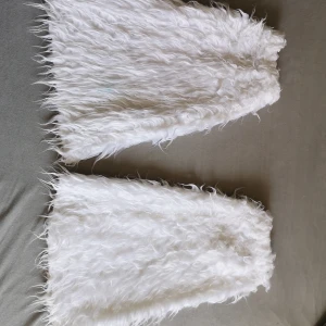 Fluffiga benvärmare - Vita fluffiga benvärmare som uppgraderar din outfit. Använda och har tecken på det. De är smutsiga så en tvätt skulle de nog behöva, köparen får tvätta. 
