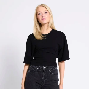 Svart omlottopp med knyt i ryggen - Svart topp med rund hals och halvlånga ärmar. Toppen har en snygg omlottdesign med knyt bak i ryggen som ger en cool och trendig look. Perfekt att styla med höga jeans eller kjol för en avslappnad vibe. (Inte min bild, fick inte till en bra bild men skicket är som på bilden och prislapp sitter kvar.)