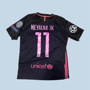 Barca NEYMAR JR tröja  - Snygg FC Barcelona fotbollströja från Nike med Neymar Jr och nummer 11 på ryggen. Tröjan är mörkblå med rosa detaljer, officiella Champions League-patchar på ärmarna och klubbmärke på bröstet. Materialet är lätt och andas, perfekt för match eller träning. Pris kan diskuterar vid snabb affär 