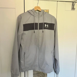 Under Armour Jacka - Extremt fin under Armour windbreaker Perfekt jacka inför blåsiga och regniga dagar dagar  Ljus grå och Svart färg med vit logga               Enda defekten är jätte små fläckar som endast är synlig vid jätte jätte noga inspektion           Storlek S på etiketten  Skicka meddelande vid några funderingar Kolla gärna även in mina andra annonse 