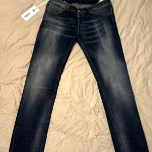 Mörkblå slim jeans med slitningar - Snygga mörkblå jeans från Dondup med diskreta slitningar och tvättade detaljer. Modellen är slim och dem sitter lite mindre en 36, fråga om mer bilder! Tags finns kvar. 