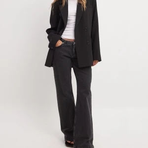 Svarta wide jeans från NA-KD - Snygga svarta jeans från NA-KD med låg midja. Helt oanvända, nypris 699kr