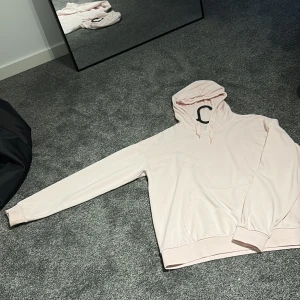 Ljusrosa hoodie från Gina Tricot - Säljer en ljusrosa hoodie från Gina Tricot med klassisk känguruficka och snörning i huvan. Mjuk insida och ribbade muddar vid ärmslut och nederkant. Perfekt för dig som gillar en enkel och stilren look.